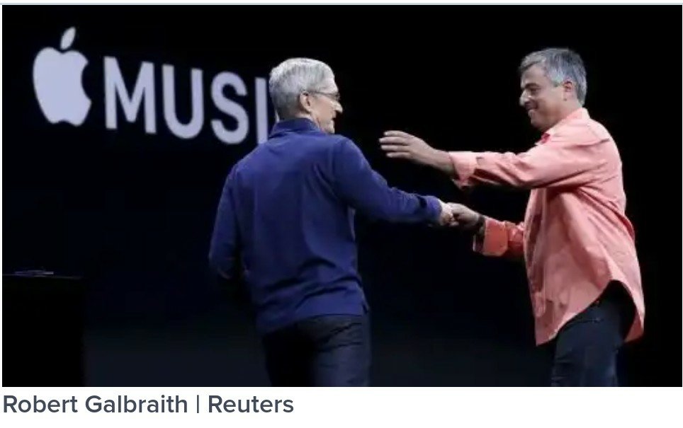 Apple CEO Tim Cook, left, greets senior vice president of internet services and software Eddy Cue